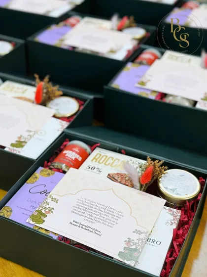 This dark green gift box contains a curated selection of gourmet snacks and a scented candle, making it a refined and thoughtful gift for any occasion.