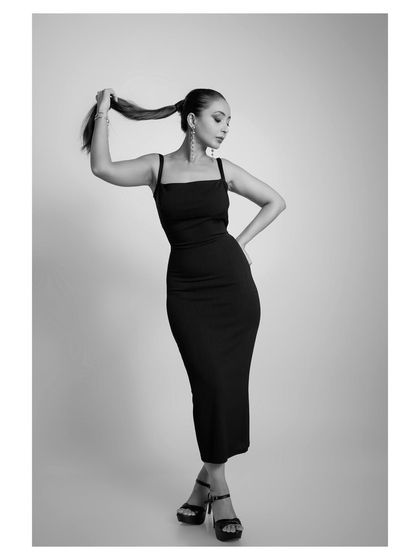 This black and white shot captures a powerful and fashionable pose, perfect for a high-fashion editorial.