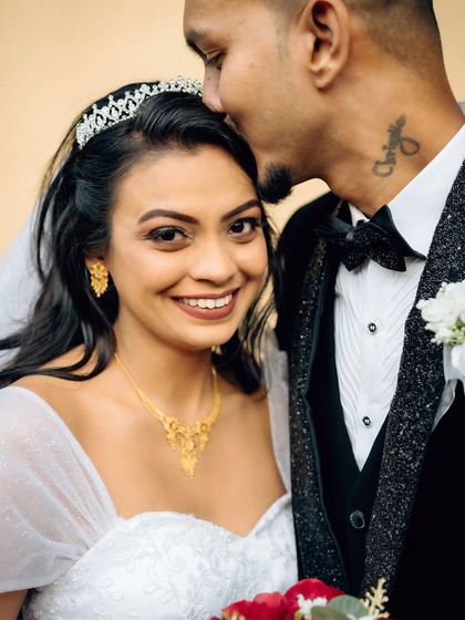 A sweet and loving portrait of the groom kissing the bride's forehead. The bride's smile directly to the camera makes this an engaging and personal shot.