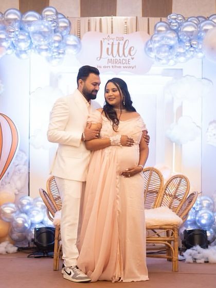 The parents-to-be posing in front of their dreamy hot air balloon backdrop. I love capturing these sweet moments where the decor perfectly complements the couple's joy.