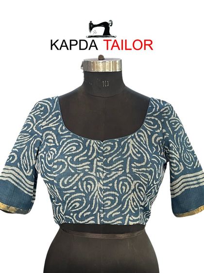 A classic U-neck blouse made from a beautiful blue and white printed fabric. The elbow-length sleeves and simple cut make it a versatile piece for your wardrobe.