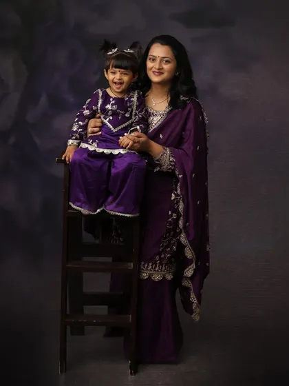 Laughter and love in matching outfits. This mother and daughter share a joyful moment, creating a beautiful memory captured in a classic, painterly portrait style.