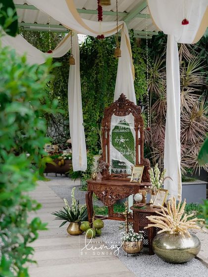 A beautiful setup featuring a traditional carved mirror and floral arrangements, showcasing a blend of Kerala elegance and Indo-Western style.