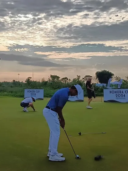 Kartik Singh practices his putting at sunset during the Nomura Cup, demonstrating his dedication.