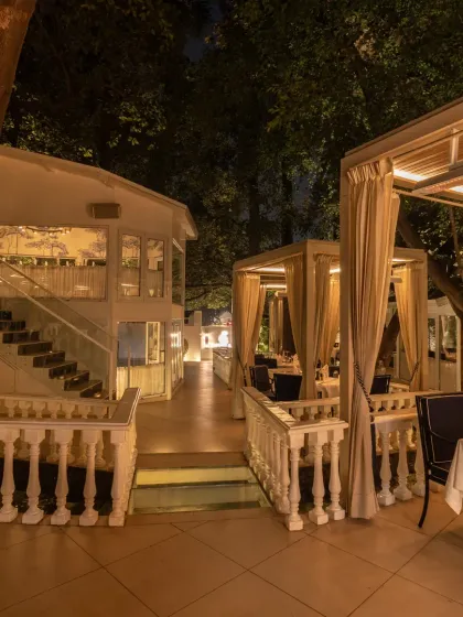 The view of our terrace at night, showing the layout of the private cabanas and the two-story indoor dining area in the background.