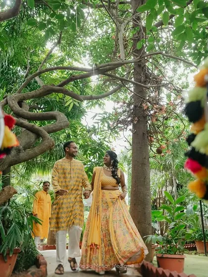 A couple enters their haldi ceremony, framed by dhol drums, capturing the fun and energy of the event.
