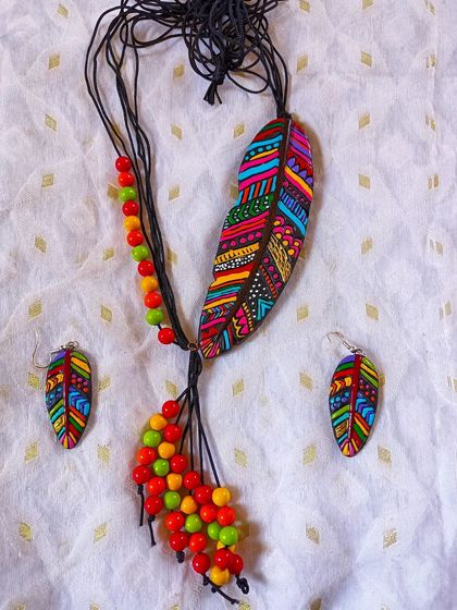 A full view of my bohemian-style feather necklace. The large, multi-colored feather pendant is paired with a cascade of colorful beads and matching feather earrings.