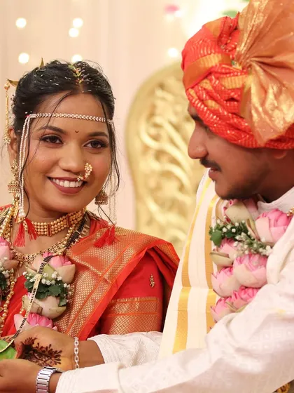 A direct look at the camera from the happy couple. The bride's makeup is fresh and vibrant, matching the celebratory mood.