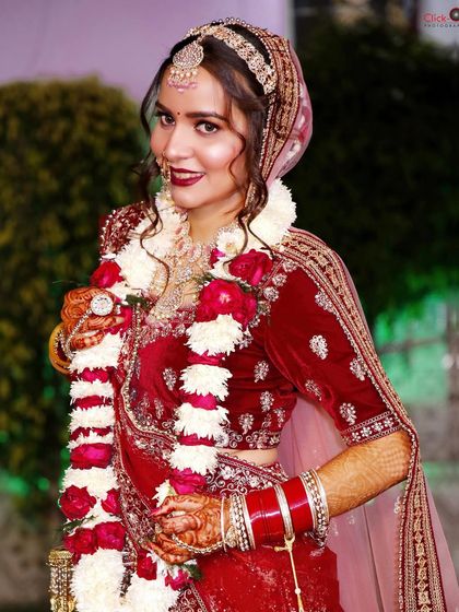 A three-quarter portrait of the same bride, capturing her full look with the varmala.