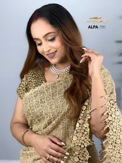 This pose highlights the delicate lace of the saree and the simple, elegant pearl necklace.
