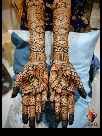 A close-up of a bride and groom portrait, nestled within a heart and surrounded by lotus flowers. This is a beautiful way to personalize your bridal mehndi.