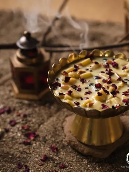 My classic Fruit Custard, a comforting and refreshing dessert. It's a creamy custard loaded with fresh fruits and garnished with rose petals, served in a traditional brass bowl.