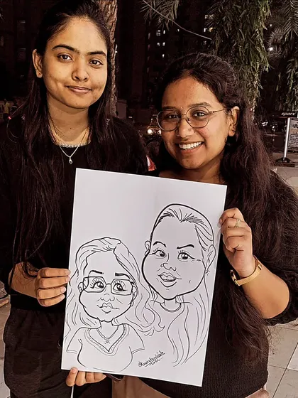 Two friends posing with their caricature. Getting drawn together is a fun activity and leaves you with a great memory to share.