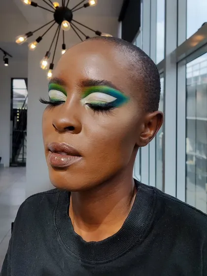 For this creative look, I blended shades of green, blue, and white to create a multi-tonal, graphic eye. The sharp white cut crease makes the colors pop, especially on deep skin tones.