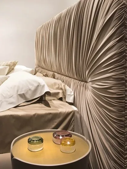The art of texture and form. This bed features a dramatic, padded headboard with soft, sculptural drapery in a luxurious fabric. It's a testament to our meticulous craftsmanship, designed to be a stunning focal point that balances contemporary design with timeless comfort.