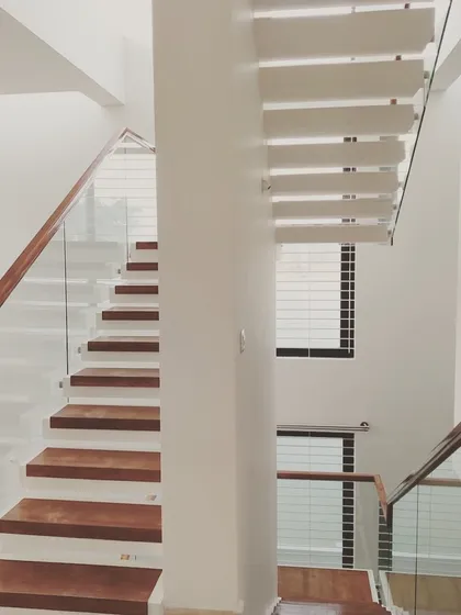 A staircase is more than just a functional element; it's a central architectural feature. In this Mysore home, we designed a floating staircase with rich wood treads and a clear glass balustrade to create a sense of openness and modern elegance.