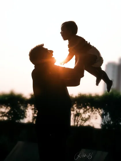 There's something so powerful about a father lifting his child to the sky. This silhouette against the sunset captures that feeling of strength, love, and endless possibility in a single, artistic frame.