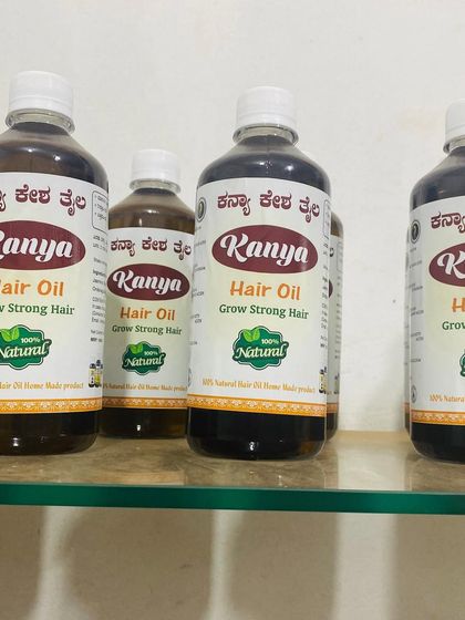 A lineup of Kanya Hair Oil bottles on a shelf, showing the different sizes I offer.