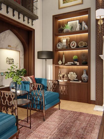 A cozy corner of the haveli, where a modern blue armchair with traditional jaali-patterned sides sits next to a classic fireplace and built-in wooden bookshelf.