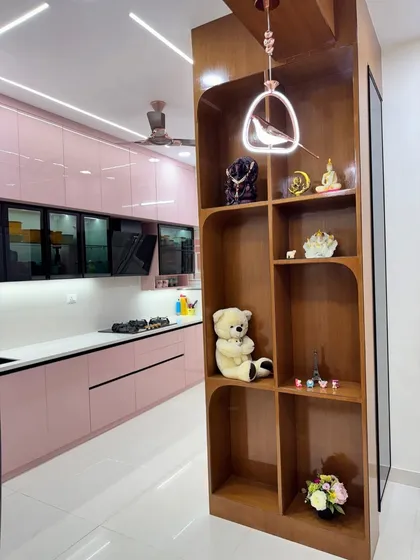 This view shows how we integrated a wooden display unit as a partition next to the kitchen. It helps define the space while providing open shelving for decor, connecting the kitchen and living areas.