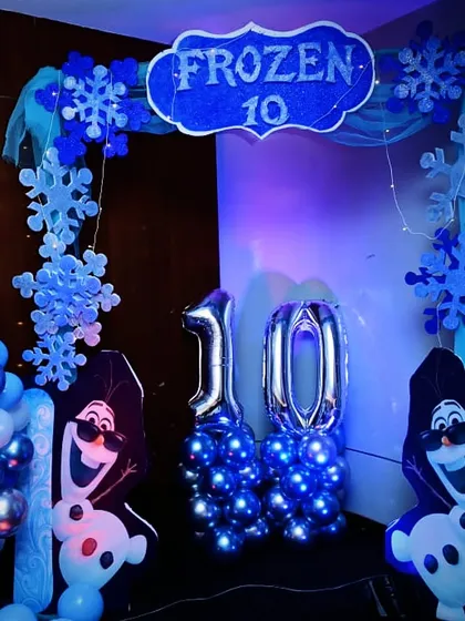 A detailed shot of the Frozen-themed photo corner, featuring Olaf cutouts and number balloons for the 10th birthday celebration.