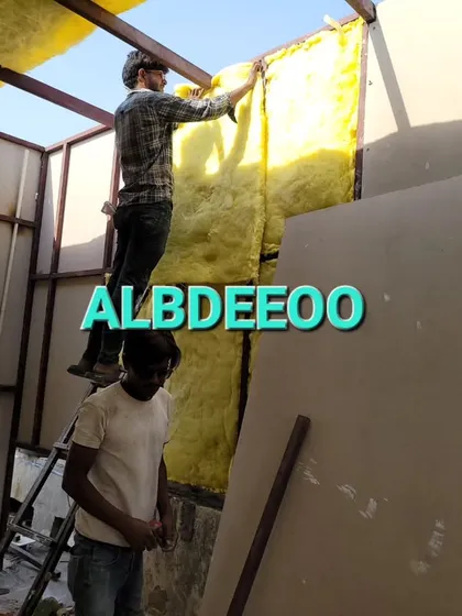 Our team installing glass wool insulation into the wall panels. This is a critical step to ensure every room we build is energy-efficient and comfortable.