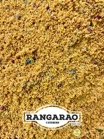 A top-down view of our classic Puliyogare, a tangy and spicy tamarind rice preparation. This temple-style dish is a staple in our festive and wedding catering menus, loved for its complex flavours.
