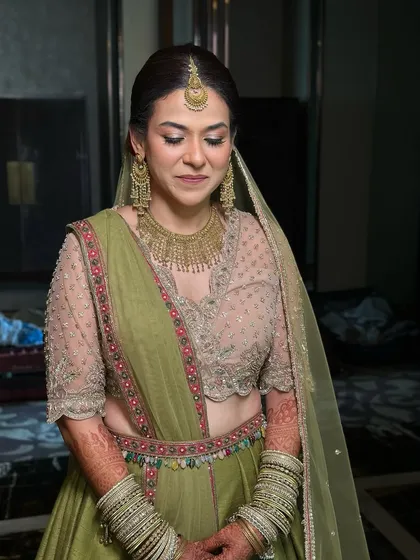 A three-quarter shot showing the full effect of her lehenga, jewellery, and radiant makeup.
