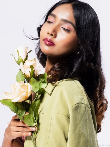 A beauty shot with the model holding roses, her eyes closed, creating a serene mood.