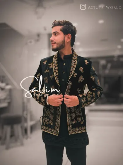 A client looking stylish in a black Indo-Western jacket with heavy gold floral embroidery. Paired with a simple black kurta, the jacket becomes the centerpiece of the outfit.