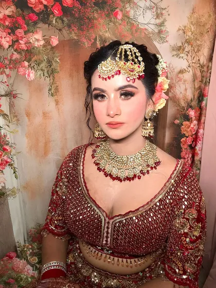 A close-up of the bride's face, her coral lips and shimmery eyes perfectly complementing her jewelry.