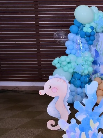 A cute seahorse cutout peeking out from behind the coral prop, showcasing the small details that make the theme special.
