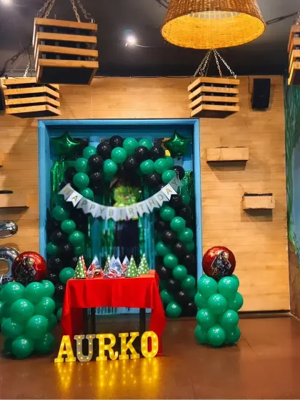 A simple yet effective green and black themed birthday setup, perfect for smaller venues or home parties.