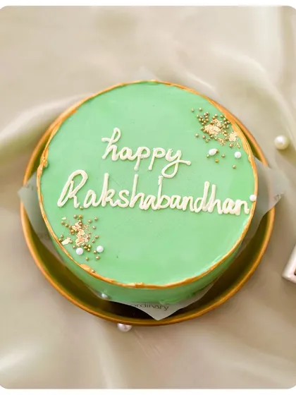 The elegant "Happy Rakshabandhan" bento cake, with beautiful script and gold sprinkles.