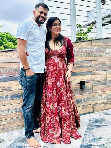 A client wearing a beautiful floral printed anarkali gown, perfect for a daytime event or festive gathering.