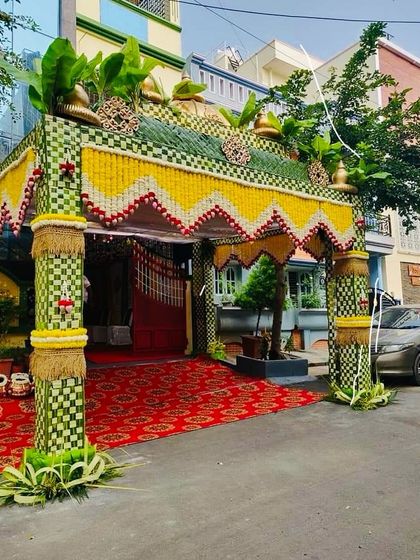 A grand and elegant entrance structure, or 'chapara', made with woven coconut leaves and fresh flowers. This is a traditional way to welcome guests for a wedding or housewarming.