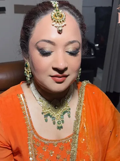 A close-up of the final look for the client in the orange suit. The makeup is flawless, with shimmery eyes and a beautiful finish that captures elegance and sophistication.