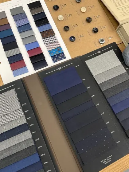 Our at-home consultation includes exploring a vast library of fabric books. Here you can see options for suitings, linings, and buttons all in one place.