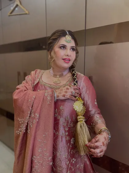 A candid moment showing the details of her outfit and the traditional braided hairstyle with a decorative tassel.