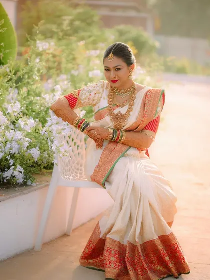 A candid moment captured. The bride's custom-designed blouse and traditional saree create a look of timeless elegance and grace.