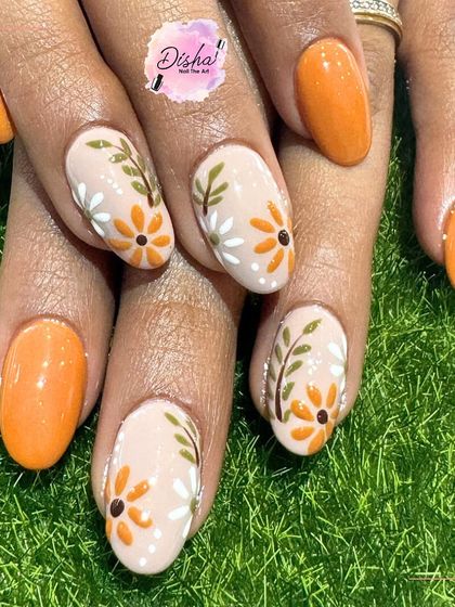 These nails are giving total sunny vibes. A bright orange base is the perfect background for these cheerful, hand-painted daisies.