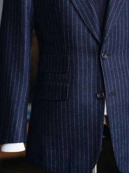 The structure of a bespoke suit is unmatched. This image shows the clean lines and sharp tailoring of a navy pinstripe jacket, a staple for any discerning gentleman's wardrobe.