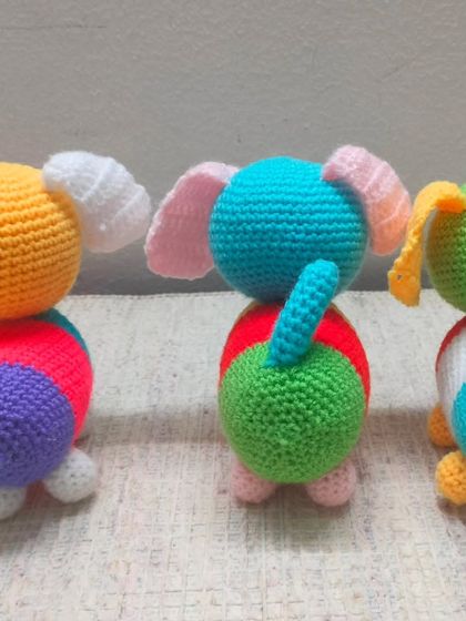 The back view of the colorful dogs, showing their little tails.