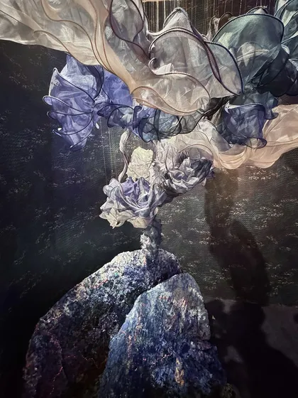 A sculptural piece from the 'Into The Deep' installation, where flowing fabric forms seem to emerge from textured rocks. The piece captures the mysterious and magical landscape of the sea.