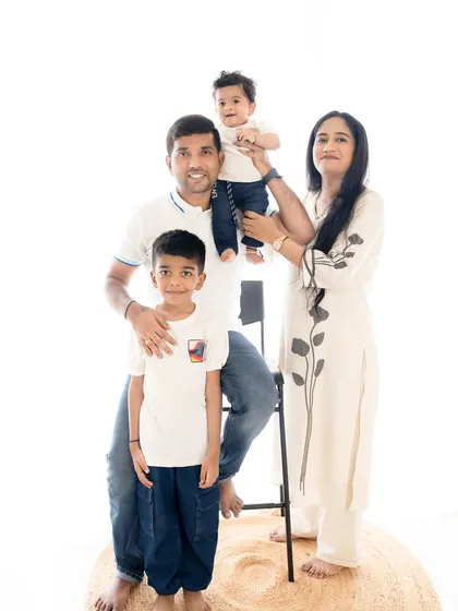 A fun and dynamic family pose using a stool. This adds height and interest to the composition, showcasing the playful relationship between parents and children.