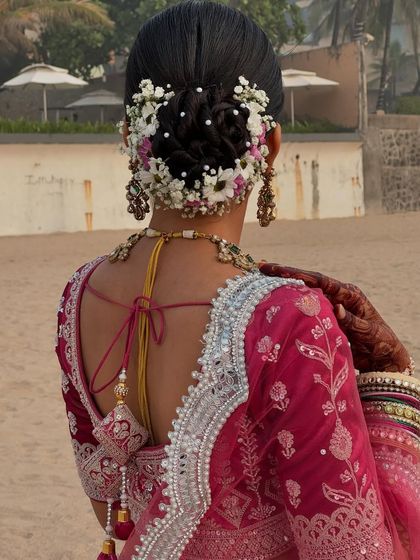 A beachside wedding calls for a hairstyle that is both elegant and can withstand the breeze. This floral bun, captured against the ocean backdrop, was the perfect choice.