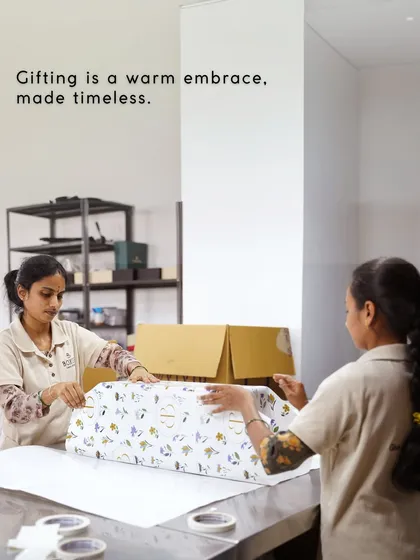 Gifting is a warm embrace, made timeless. Two of my team members are seen here wrapping a large gift with precision and care.