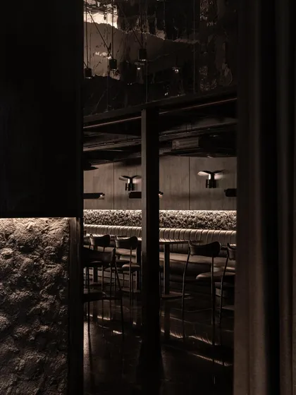 A view from behind a curtain, looking into the dining area, adding to the speakeasy's sense of voyeurism and secrecy.
