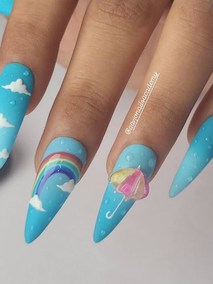 A cheerful and whimsical monsoon-themed set. It features a sky-blue ombre base with hand-painted clouds, a rainbow, and a tiny 3D umbrella, complete with 3D raindrops.