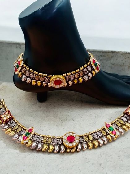 A different design of our silver fusion payal. This pair has intricate dual-tone work with red and green stones, giving it a rich, bridal feel.